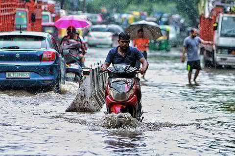 Vehicles ply on a waterlogged road in Delhi